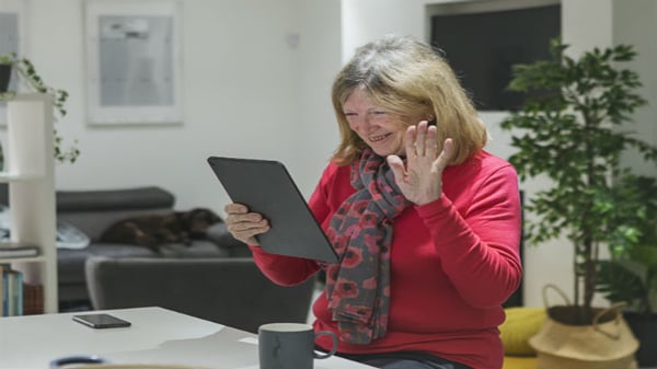 Woman waving at ipad